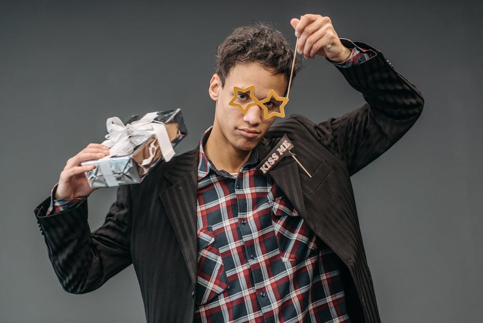 Presenter till kille Cheerful man in star-shaped glasses holding a gift box, embracing festive spirit.