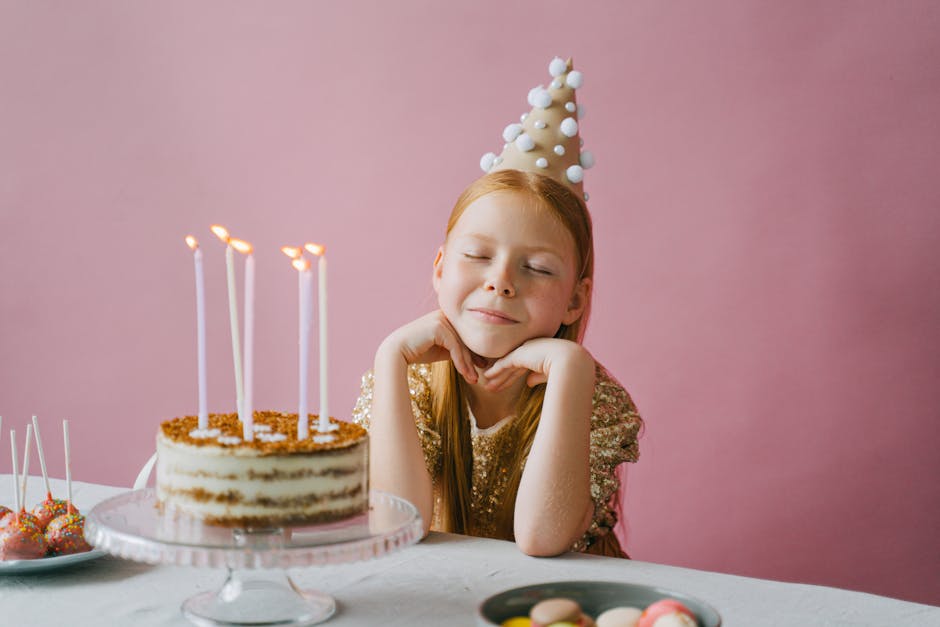 Presenter till barn A young girl celebrating her birthday with a cake, wearing a festive party hat.